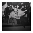 Black and white photo of a man in a crowd at a party