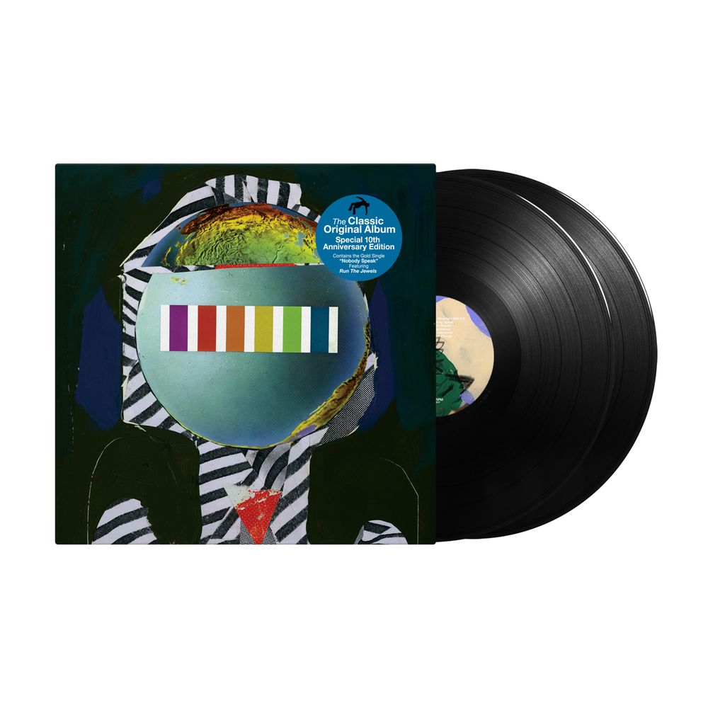 Vinyl record album with the cover partially covering a black LP, shown on a plain white background. The cover art features a surreal figure in black-and-white striped clothing with a blue-green helmet and a colorful vertical stripe panel.