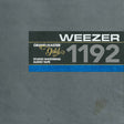 The front cover of a Weezer Grand Master Gold 1192 Studio Mastering Audio Tape, featuring a textured gray background with a black label containing white and gold text and a blue stripe.
