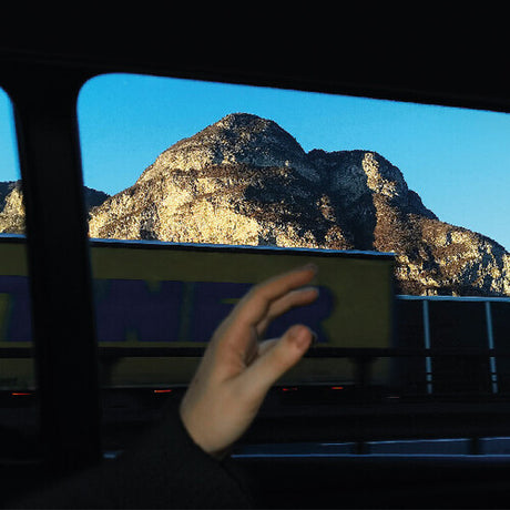 Hand holding a smartphone with a mountainous landscape in the background