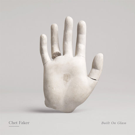Album cover of 'Built On Glass' by Chet Faker featuring a stone hand sculpture.