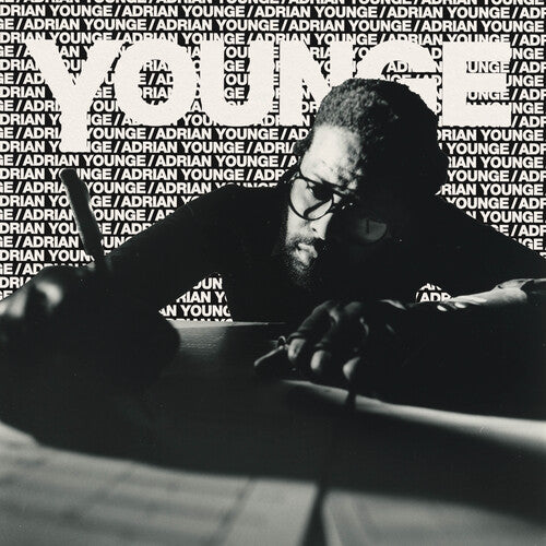 Person sitting at a table with 'Adrian Younge' branding in the background
