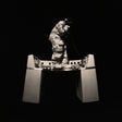 Person in a protective suit standing on a large metallic object against a black background