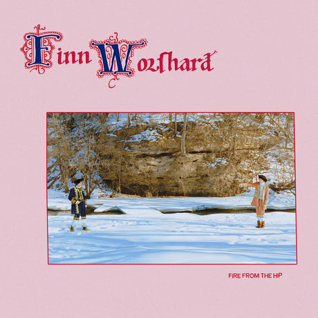 Finn Wozhard 'Fire From The Hip' album cover featuring a pink background with the artist's name in ornate red and blue lettering at the top and a central square photograph of two people standing in a snowy outdoor landscape.