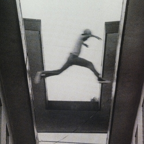 Black and white image of a person running on a tiled floor.