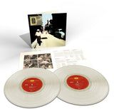 A double vinyl record album set displayed on a white background, including two translucent off-white records with red labels, an open inner sleeve with printed inserts, and the outer cover standing upright showing a vintage street scene.
