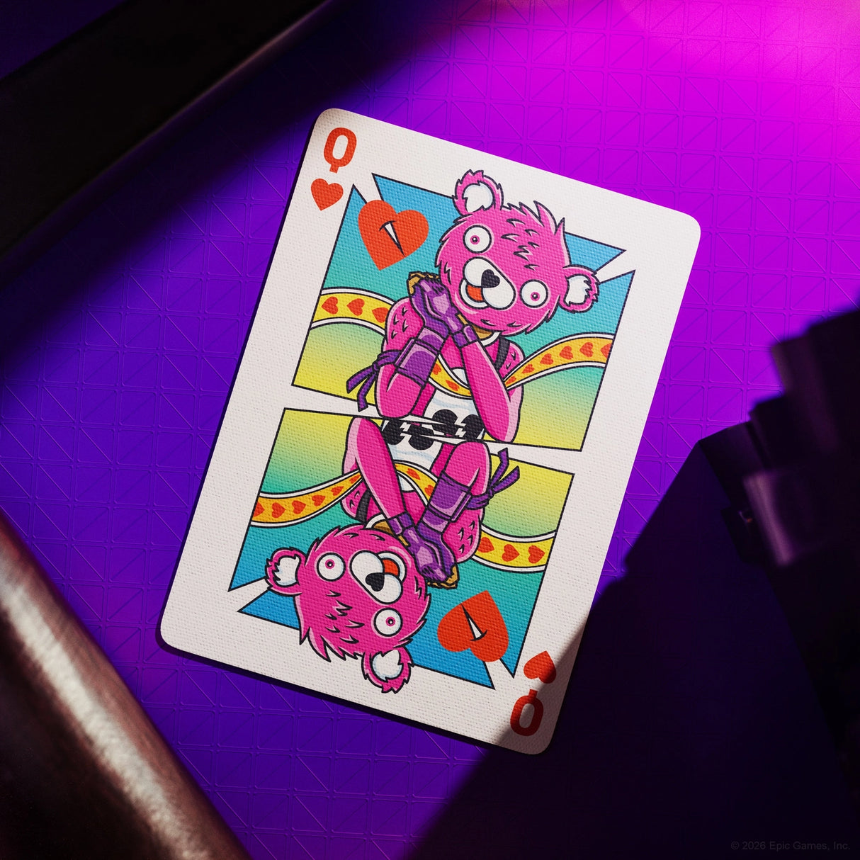 Playing card with a pink bear design on a purple surface