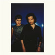 Two people standing side by side against a dark background