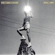 Person on a rock with a light source over their head against a power line background