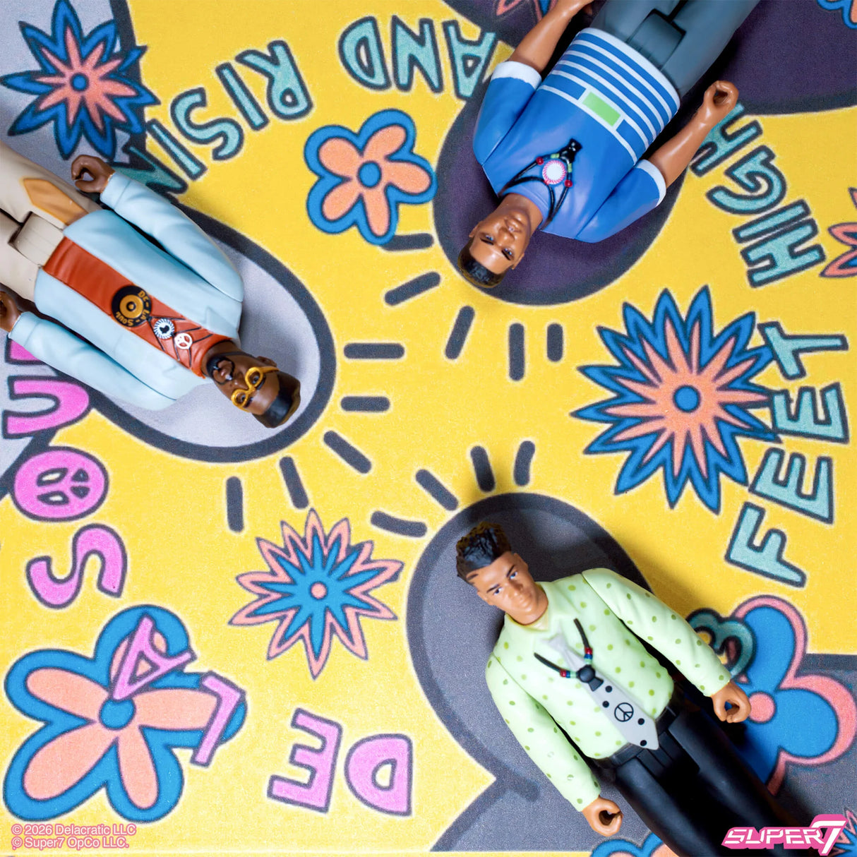 Toy figures on a colorful mat with text and floral designs