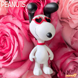 Snoopy figurine with heart-shaped sunglasses on pink roses