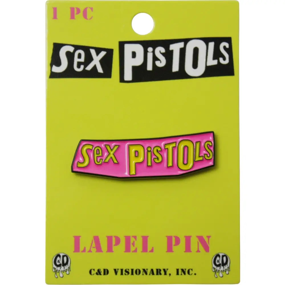 A 'Sex Pistols' lapel pin displayed on its original lime green backing card. The pin features the band's name in yellow with a dripping black outline on a pink background.