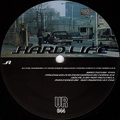 Disc with 'Hard Life' text and urban scene on a black background