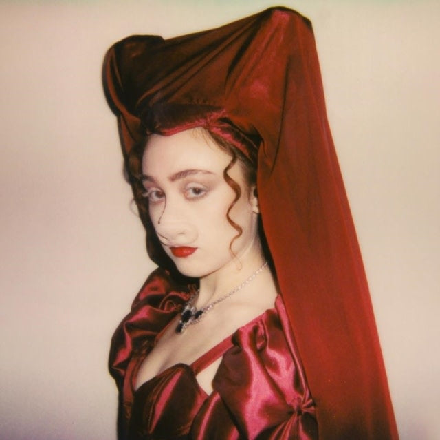Person wearing a red headscarf and dress with a plain background