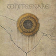 Album cover art for Whitesnake, featuring the band name in stylized lettering at the top and an ornate gold seal emblem in the center on a cracked beige stone-like background.