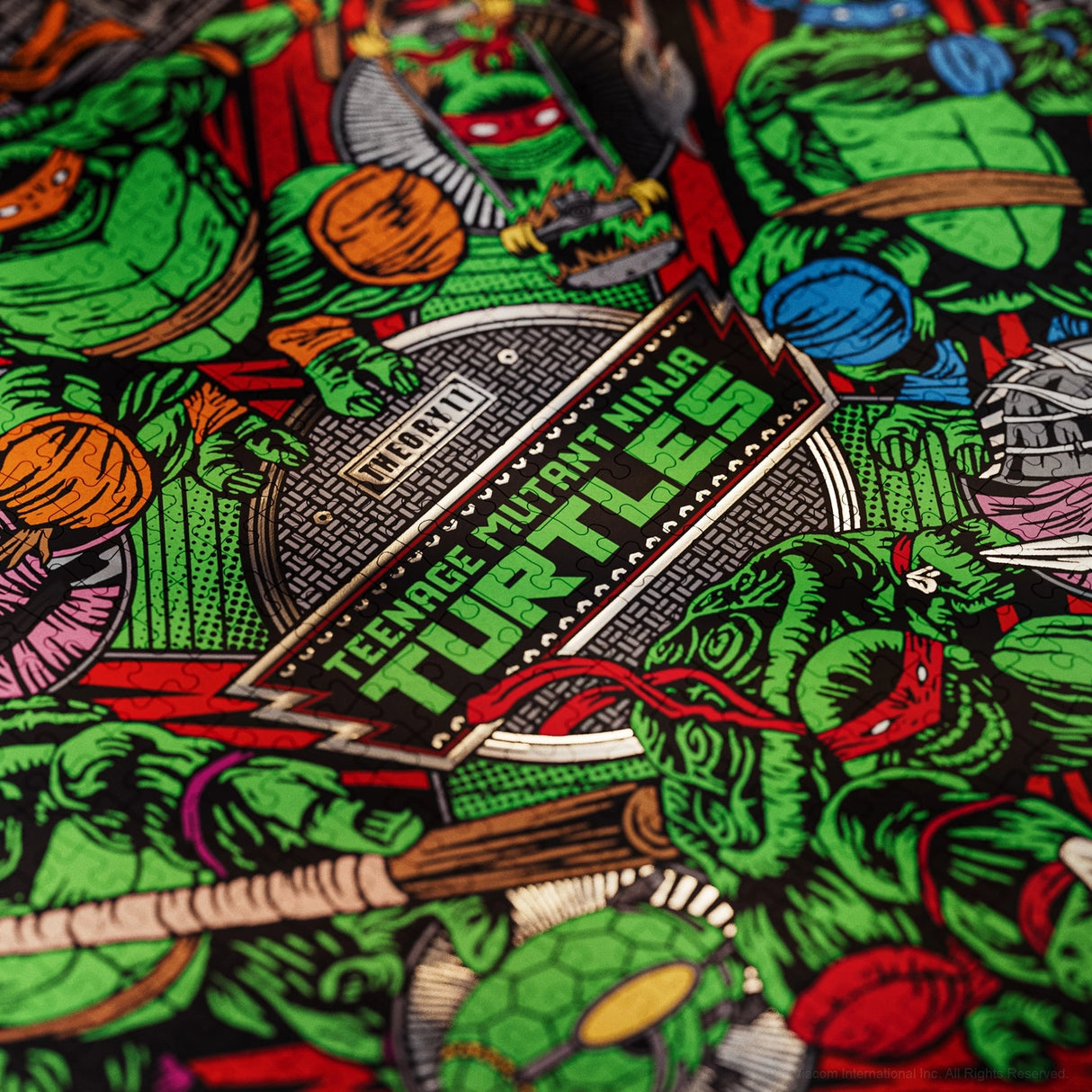 Close-up of a printed fabric featuring the Teenage Mutant Ninja Turtles character art and logo patch design, with green turtles, red and blue masks, and black background.