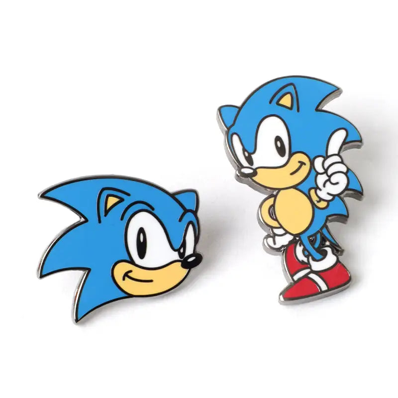 Two Sonic the Hedgehog enamel pins on a white background, one showing a close-up of Sonic's head and the other showing a full-body view of Sonic pointing upward.