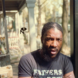 Man with a beard wearing a 'Fathers' shirt in an outdoor setting