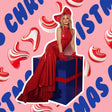 Woman in a red dress sitting on a blue gift box with Christmas-themed background