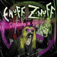 Album cover art for Enuff 'Znuff' titled 'Live in the Muddy & Go Go', featuring a stylized portrait of the artist with long yellow hair, black clothing, and a microphone, surrounded by purple and green graphic elements.