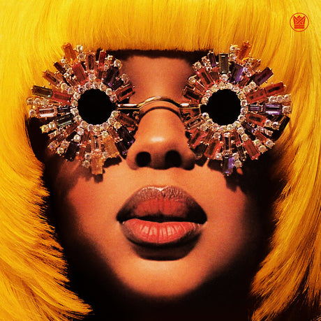 Person wearing sparkling sunglasses and a yellow outfit with a close-up of the face.