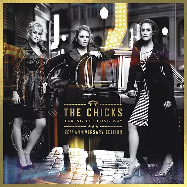 The Chicks 'Taking the Long Way' 20th Anniversary Edition album cover art, featuring the three band members posing in front of a vintage car on a cobblestone street.