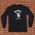 Black long-sleeve shirt with graphic design on a brick wall background