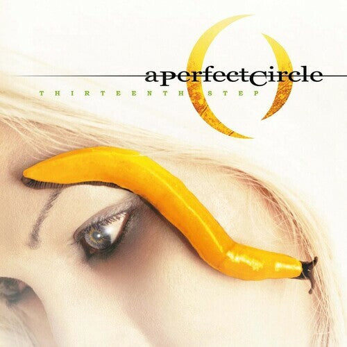 Album cover for 'Thirteenth Step' by a perfect circle featuring a banana on an eye.
