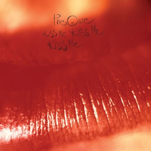The album cover features a close-up, grainy image of lips, with the title 'The Cure - Kiss Me, Kiss Me, Kiss Me' written in a stylized font resembling lipstick marks.