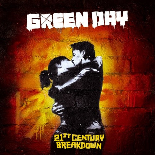 Cover art for Green Day's album 21st Century Breakdown featuring a black and white image of a couple kissing on a wall with a red and yellow painted background. The album title is at the top in bold white letters.