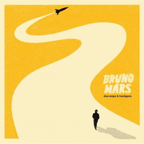 Album cover for Bruno Mars' Doo-Wops & Hooligans featuring a yellow background with a white road leading to an airplane, and a silhouette of a person walking.