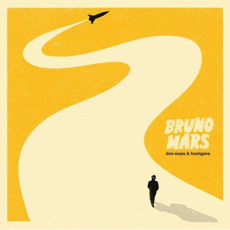 Album cover for Bruno Mars' Doo-Wops & Hooligans featuring a yellow background with a white road leading to an airplane, and a silhouette of a person walking.