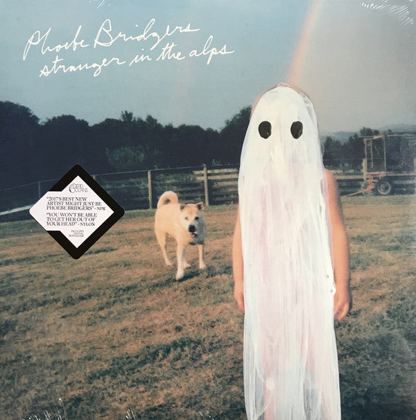 Album cover featuring a person in a white ghost costume with black eyes standing next to a dog on a field. The person is facing the camera with a neutral expression.