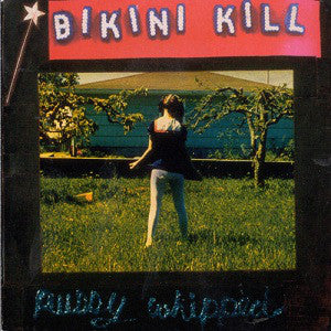 Album cover for Bikini Kill's 'Pussy Whipped LP' featuring a person standing in a field with a backdrop of trees and sky.