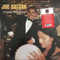 Record album cover featuring a man in a tuxedo, presumably the artist Joe Bataan, smiling at the camera with a woman in the background.