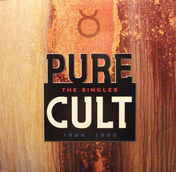 Album cover for The Cult - Pure Cult - The Singles 1984-1995 featuring a close-up of a wooden surface with the band's logo and text overlay.