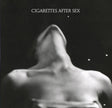 This image features the album cover for "Cigarettes After Sex - EP I," encapsulating a moody and enigmatic atmosphere. The artwork displays a blurred, abstract figure set against a dark background with subtle star-like dots adding a hint of texture.