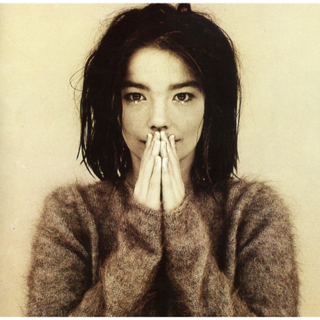 A vinyl record album cover featuring a young woman with her hands pressed together in front of her face. She is wearing a brown, textured top and the background is plain.
