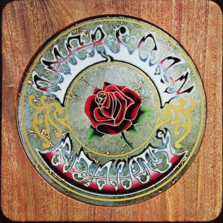 A vinyl record of Grateful Dead - American Beauty with a colorful album cover featuring a rose and decorative text.