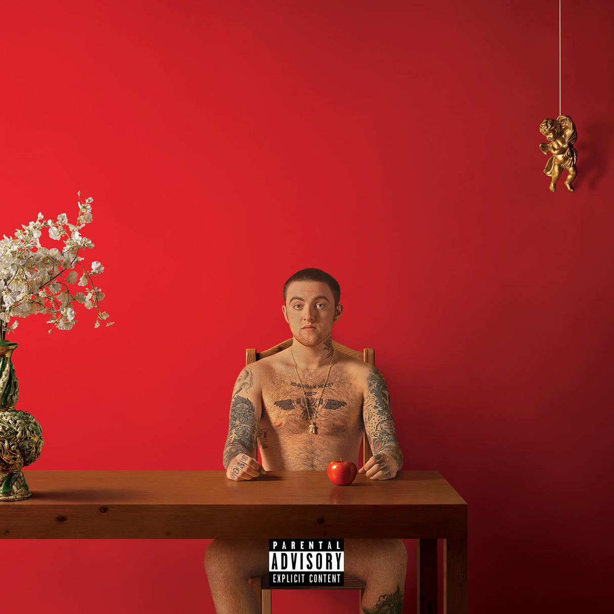 The image features the cover art for Mac Miller's album "Watching Movies 2LP." The cover depicts Mac Miller seated nude on a wooden chair against a vibrant red background, holding an apple.