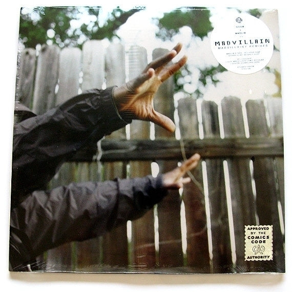 A vinyl record album cover featuring a person's hands reaching towards a wooden fence with a blurred background.