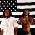 Two members of the OutKast hip hop group posing against a background with an American flag.