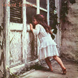 Album cover featuring a young child in a white dress standing next to a dilapidated door.